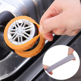 Close-up of orange rubber luggage wheel cover being stretched over a suitcase wheel, highlighting flexible and durable material.