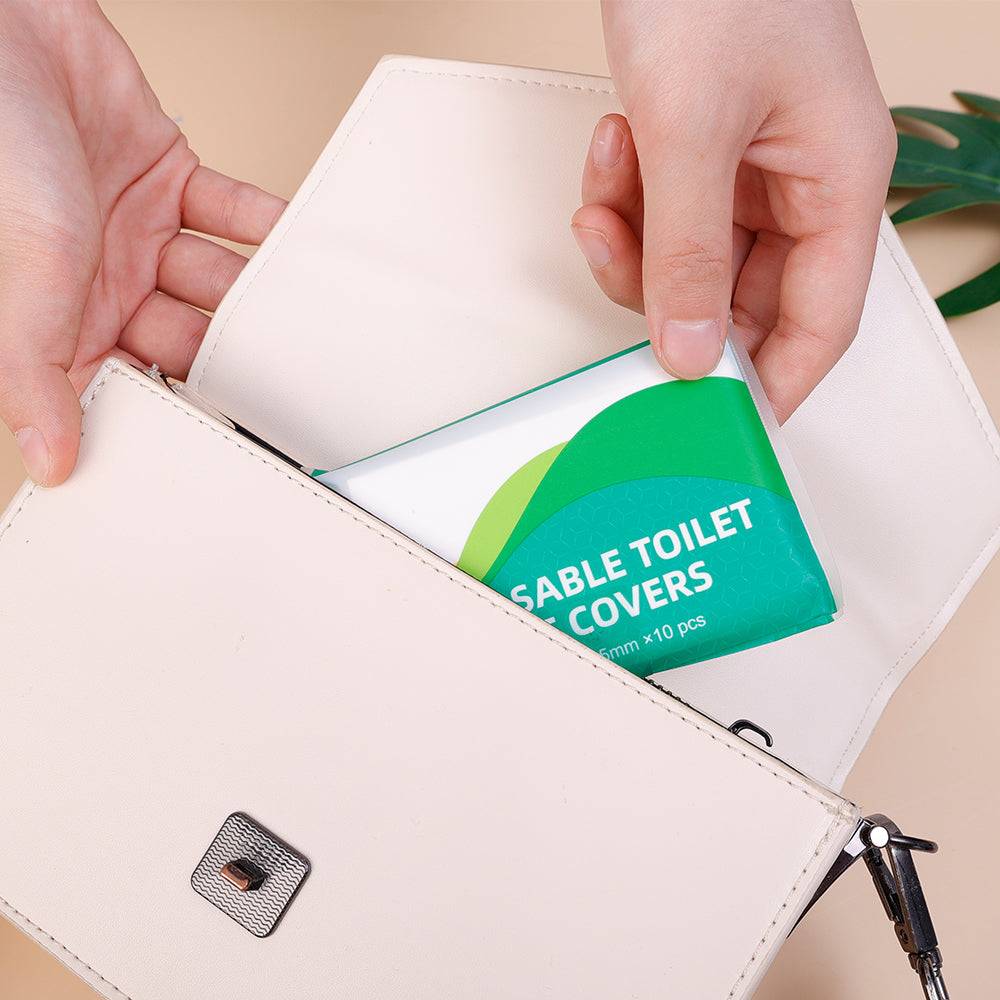 Compact 10PCS pack of disposable toilet seat covers being placed into a handbag, perfect for on-the-go hygiene and convenience.